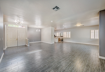 Spacious living room with new hardwood floors and large windows in a remodeled Burbank home.